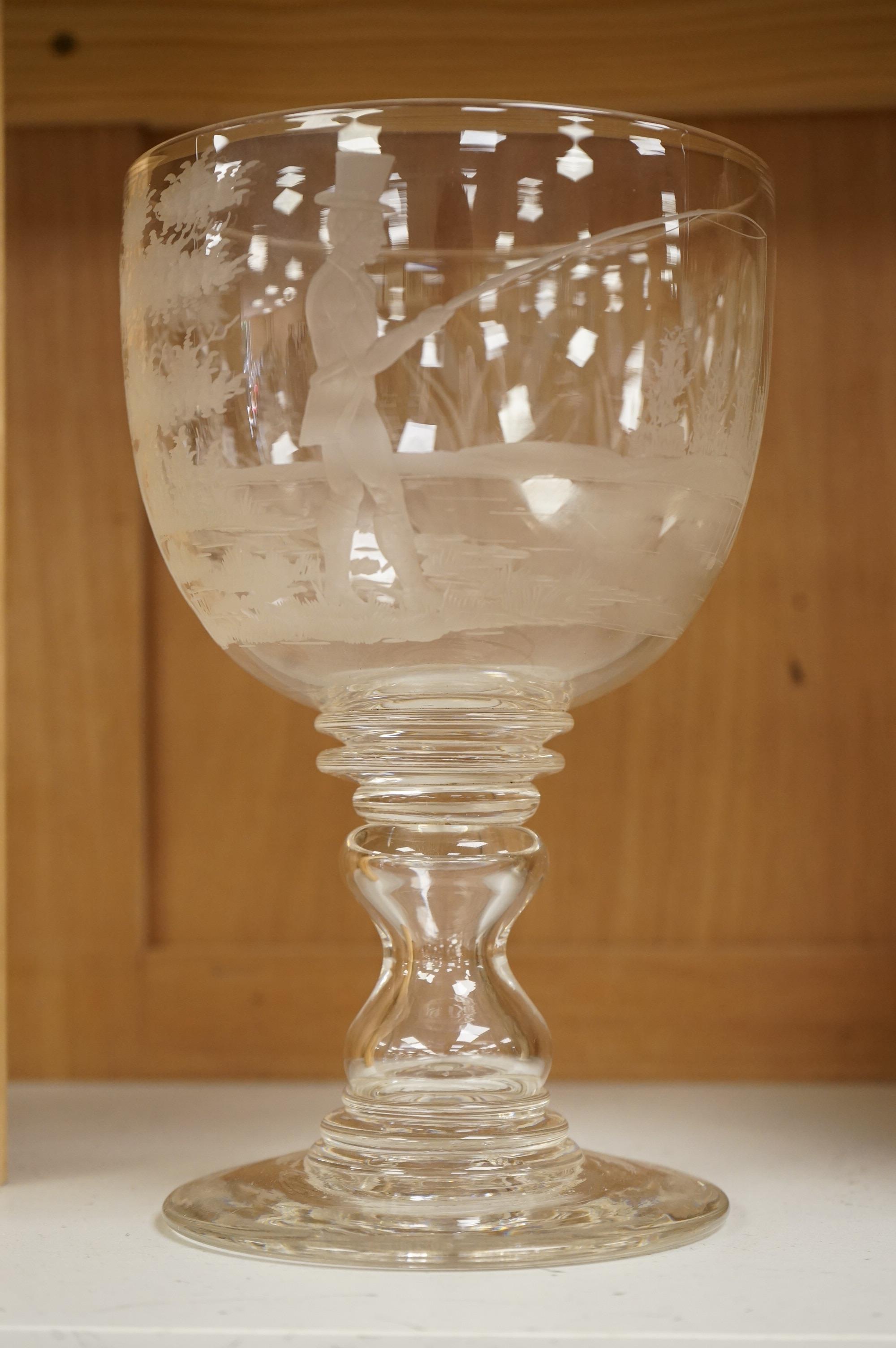 Fishing interest, a large mid 19th century glass goblet, engraved with a fisherman, bull rushes and foliage, 23cm high